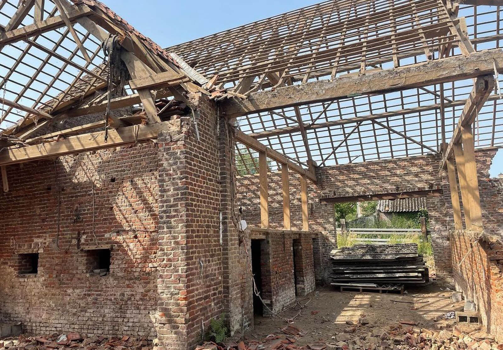 Gebouw met afgebroken dak, klaar voor verdere afbraak en asbestverwijdering
